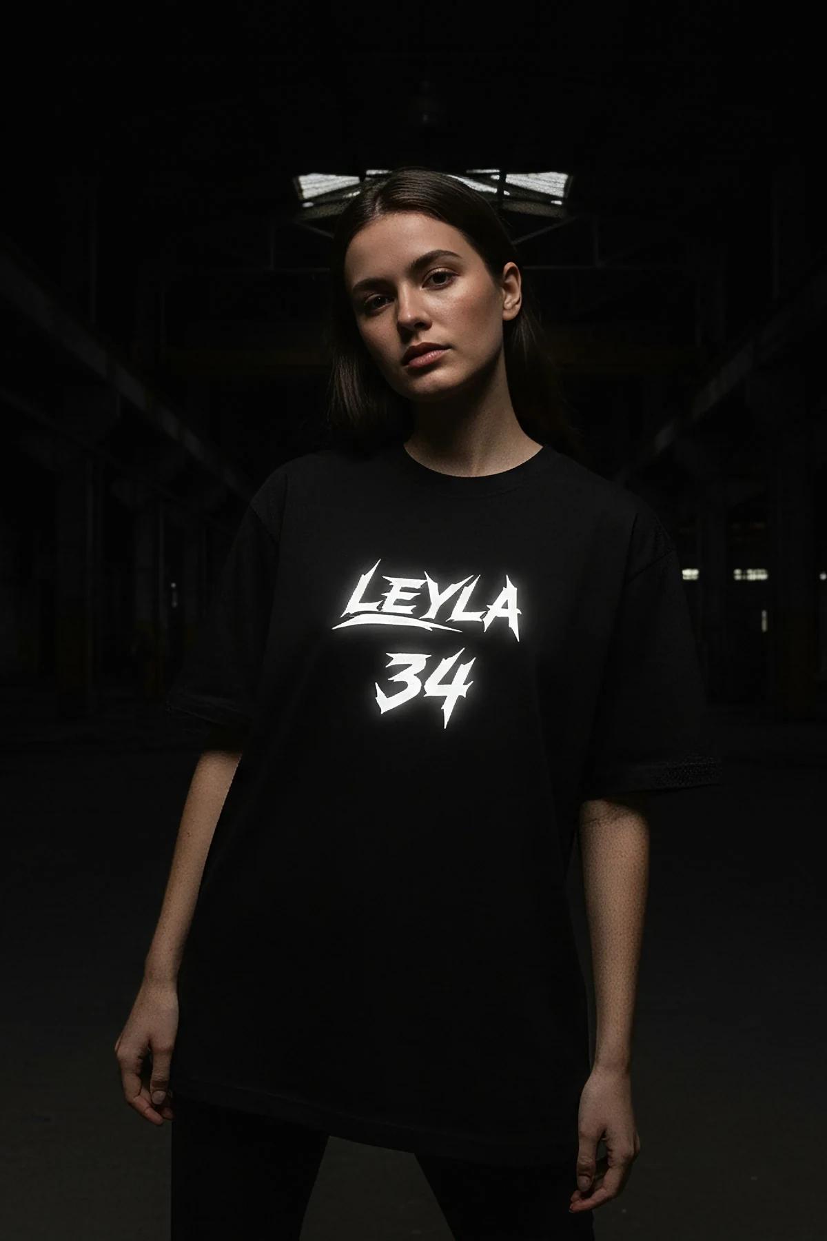 Oversized black cotton t-shirt with white graffiti-script graphic print, drop-shoulder cut and elongated hem
