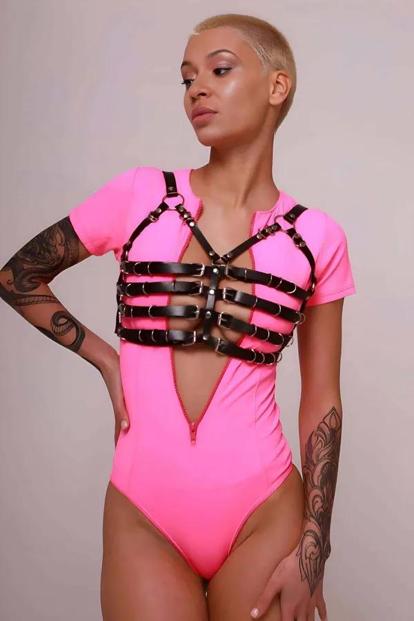 siyah vegan deri göğüs harness çok bantlı altın toka ve O-halka detayı neon pembe bodysuit üzerinde