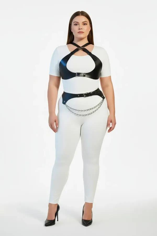 black faux leather harness set with cross-strap chest piece and layered silver waist chain belt worn by plus-size model