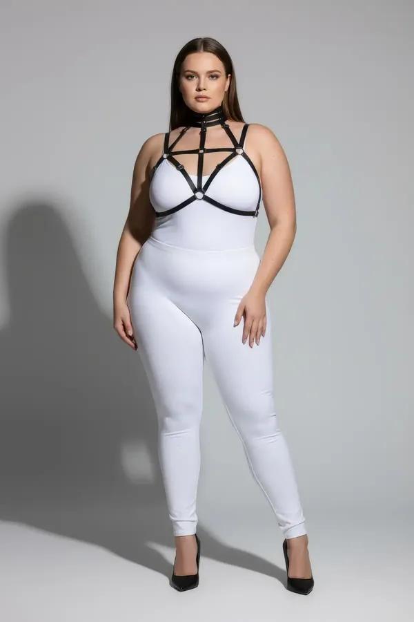 black faux leather strappy chest harness with choker neck and silver O-ring hardware worn over white bodysuit