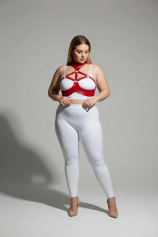 Red faux leather collar and chest harness set with gold-tone cage straps on plus-size model, white background