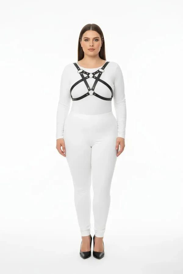 black faux leather chest harness with crossed straps silver studs and central O-ring worn over white outfit