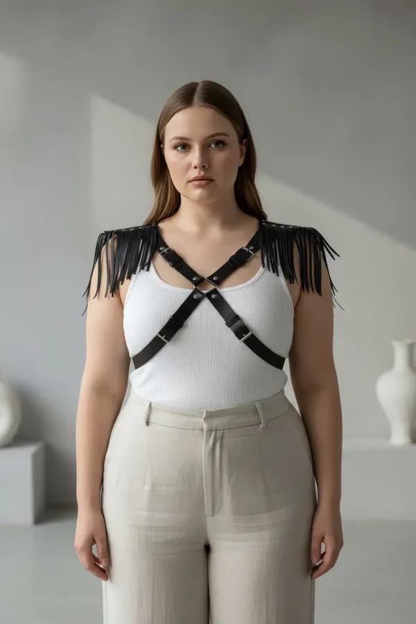 black faux leather fringed shoulder chest harness with adjustable X-cross straps and silver buckles worn over white tank top