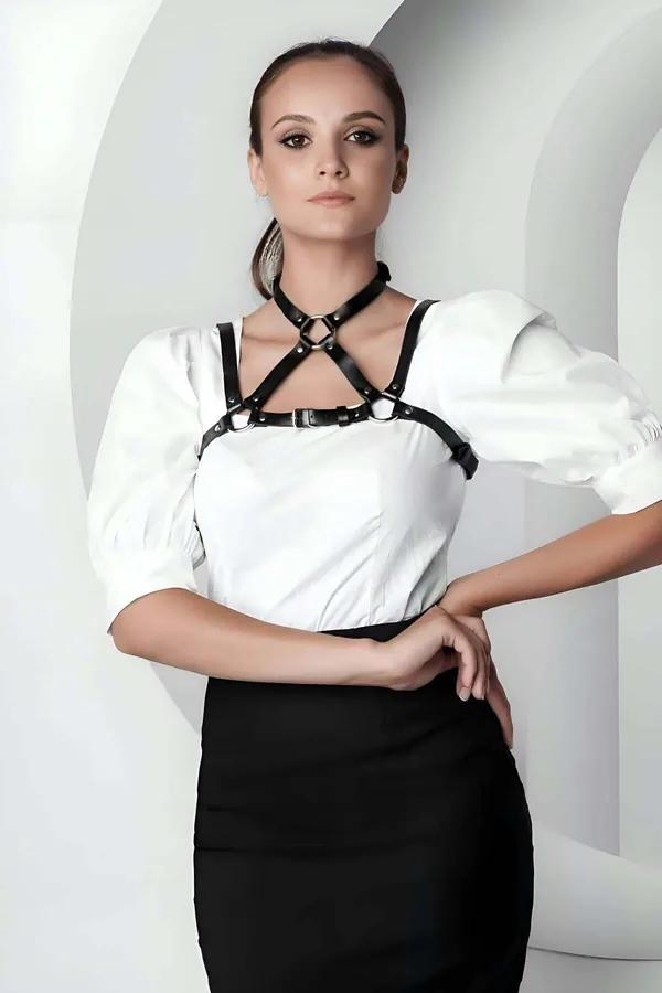 Siyah vegan deri crop yaka harness, gümüş O-halka ve toka, beyaz bluz üzerine giyilmiş kadın