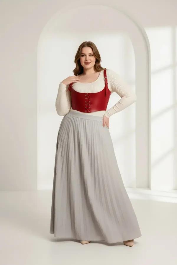 red faux leather underbust corset harness with front eyelet lacing and silver buckle shoulder straps worn over cream top