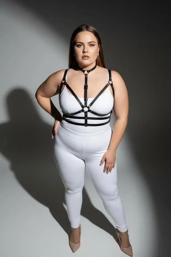 black faux leather strappy choker harness bra with silver O-ring center and multi-strap underbust bands worn on plus-size mod
