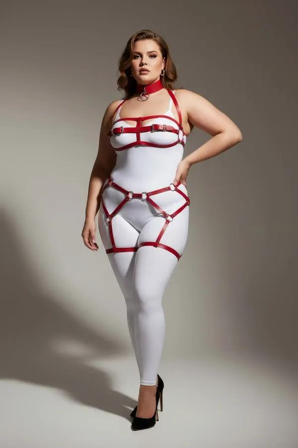 Red faux leather full body harness set with O-ring choker, structured chest frame, and dual thigh garter straps on plus-size