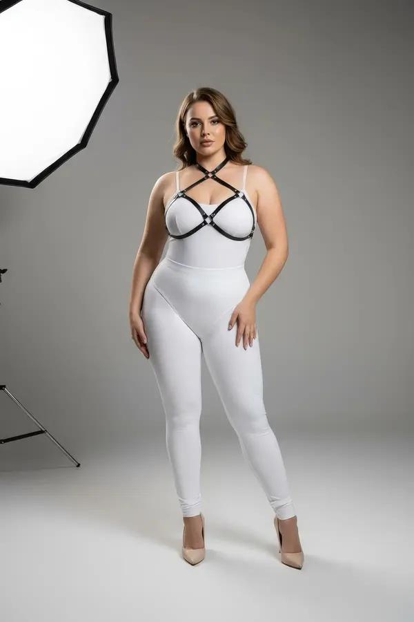 Black faux leather strappy o-ring chest harness with silver connectors worn over white bodysuit, plus-size model