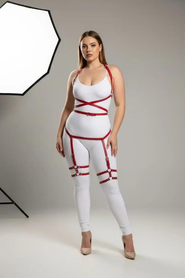 red faux leather full body harness with thigh straps and silver buckles worn over white bodysuit