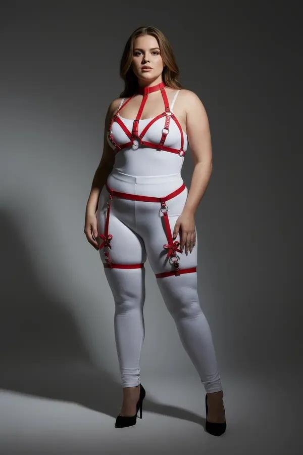 red faux leather garter harness with chest cage silver O-rings and thigh bow accents on plus-size model