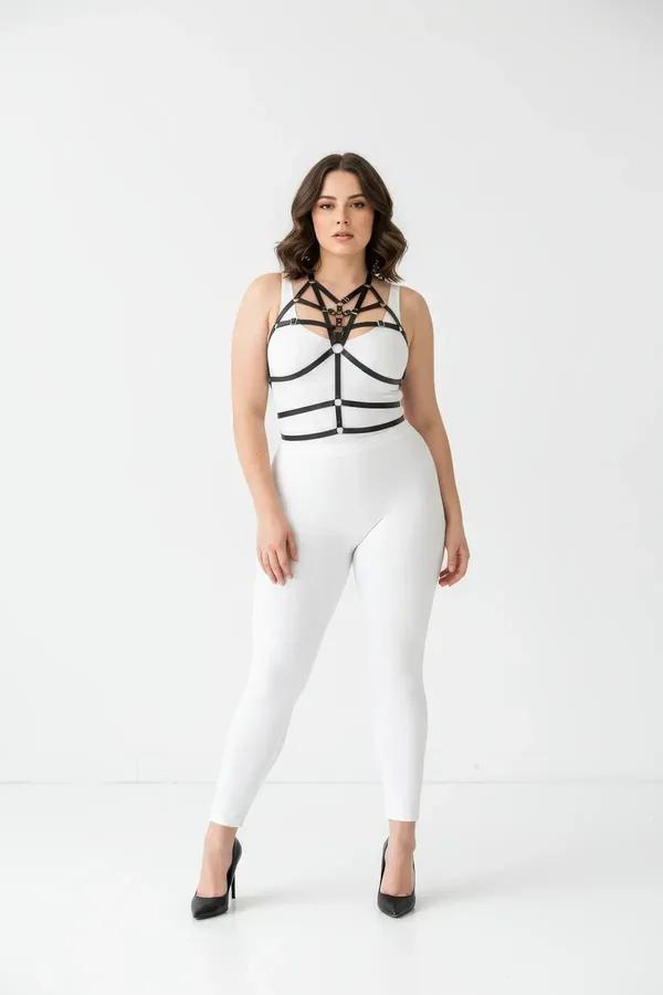 black faux leather caged chest harness with multi-strap cage and gold O-ring worn over white bodysuit