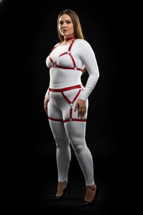 Red faux leather full body harness with silver O-ring choker, chest frame, and thigh garter straps on plus-size model