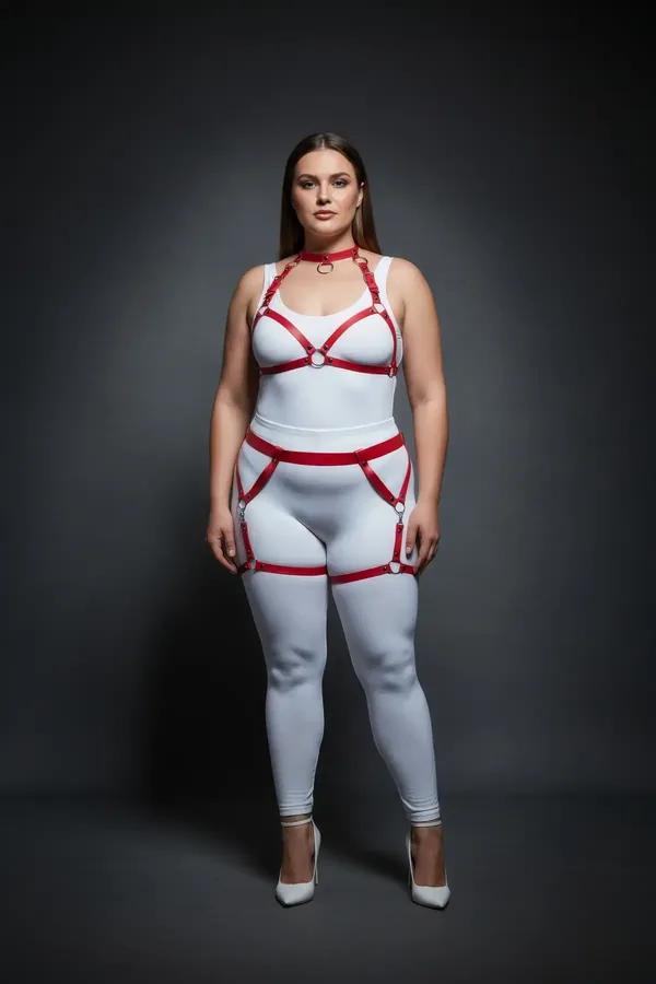 Red faux leather full body harness with silver O-ring choker, chest frame, and thigh garter straps on plus-size model