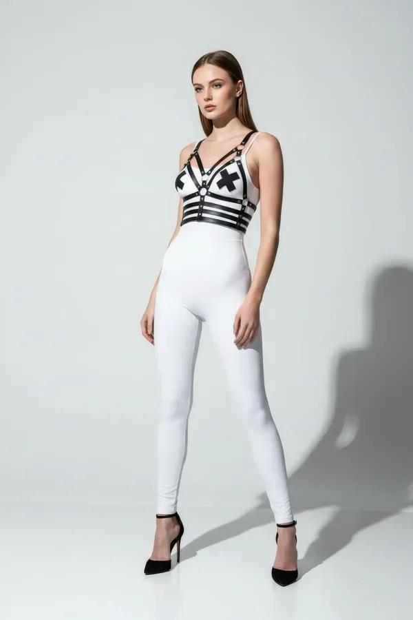 black faux leather chest harness with X-detail and three horizontal straps worn over white crop top