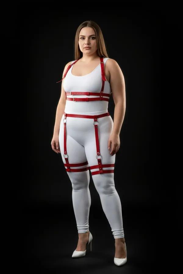 Red faux leather full body harness with dual thigh straps and silver O-ring buckles worn over white base layers