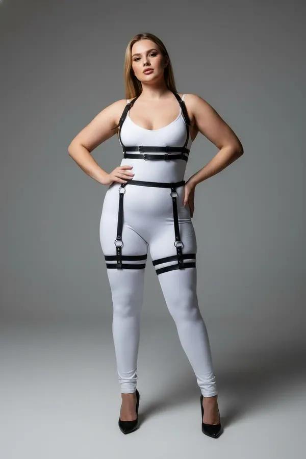 black faux leather body harness with garter straps worn over grey tank and jeans, double thigh bands and chest cage visible