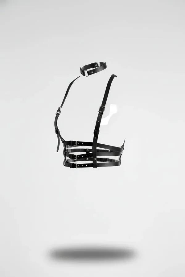 Black faux leather multi-strap cage body harness with matching choker, silver-tone buckles, floating product shot on white ba