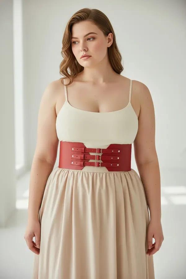 red faux leather wide corset waist harness belt with gold double buckles and decorative metal studs worn over cream top and p