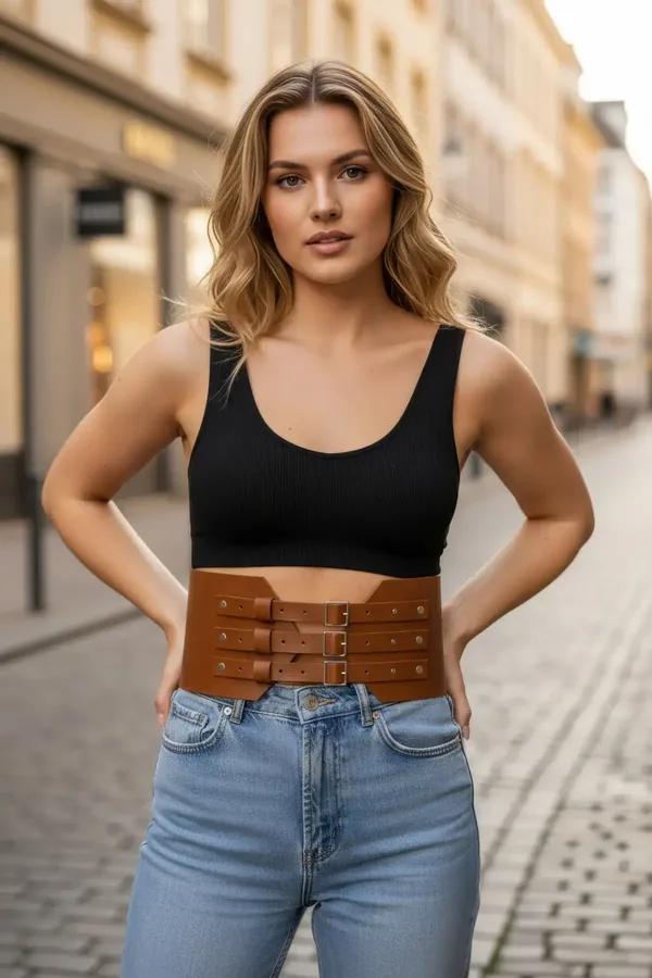 tan faux leather triple buckle waspie waist belt with silver-tone pin buckles worn over black crop top and jeans