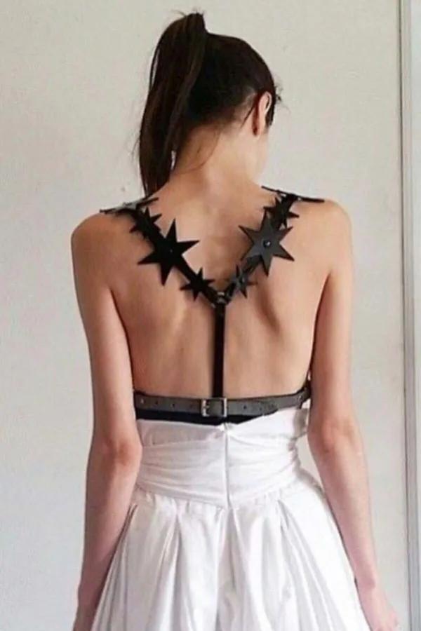 siyah suni deri yıldız detaylı sırt harness kemer, açık sırtlı beyaz elbise üzerinde, metal tokalı bel bandı