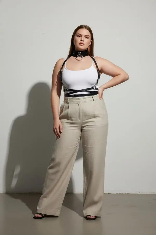 black faux leather body harness with gold O-ring choker and waist belt worn over white tank top