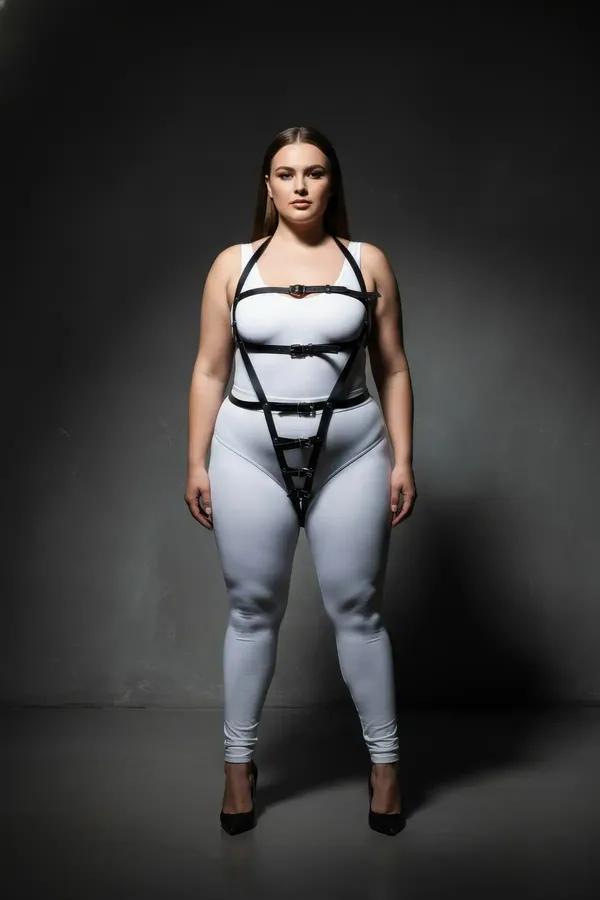 black vegan leather full body harness with inverted V-strap triangle design and silver buckles worn by plus-size model