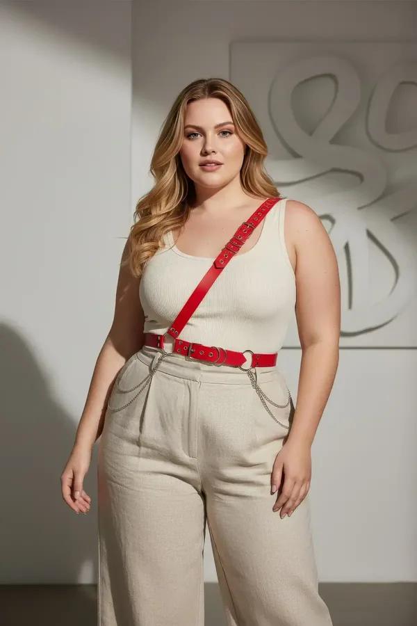 red faux leather single shoulder body harness with silver studs and O-ring worn over white tank top