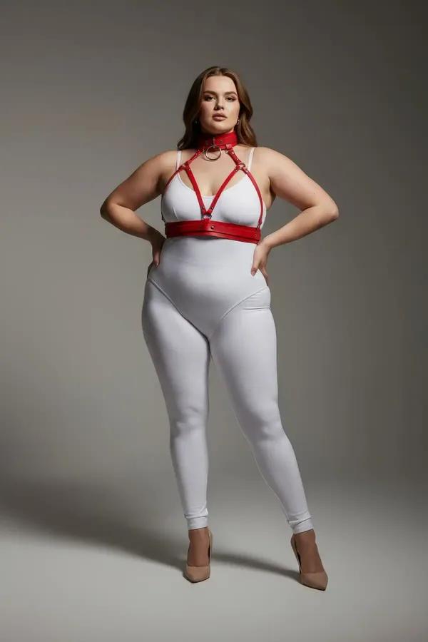 red faux leather strappy chest harness with matching choker collar and gold O-ring on plus size model