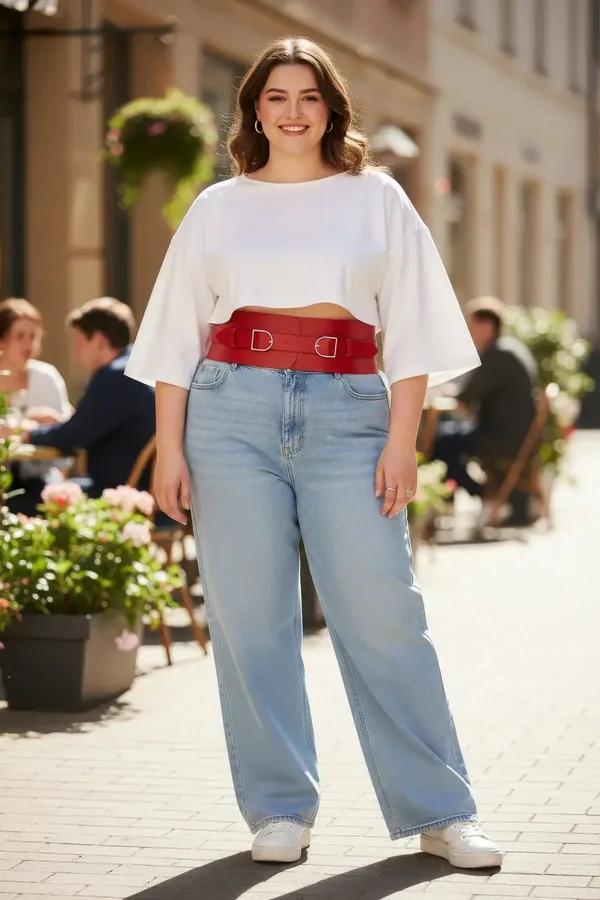 Red wide faux leather waist harness with two silver D-ring buckles worn over white crop top and light blue jeans