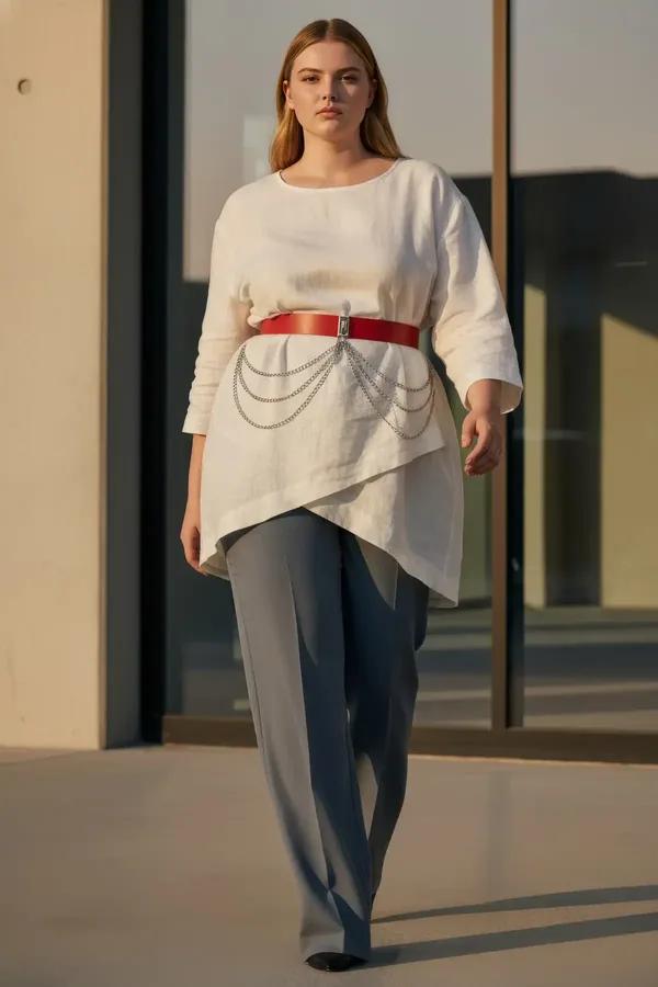 red faux leather wide waist belt with draped silver chains worn over white blouse and grey trousers