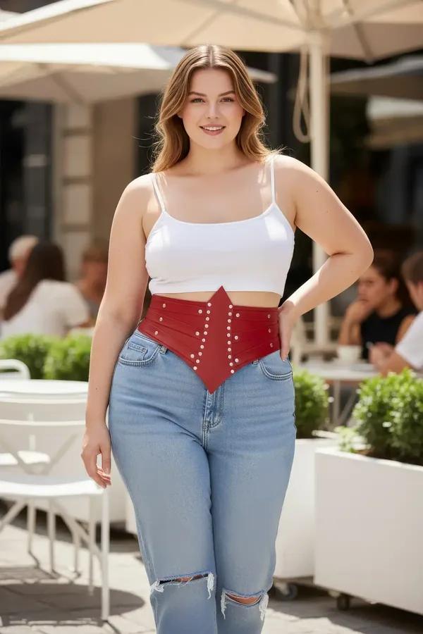 red faux leather waist harness corset belt with silver dome studs and pointed V-front panel worn over white crop top
