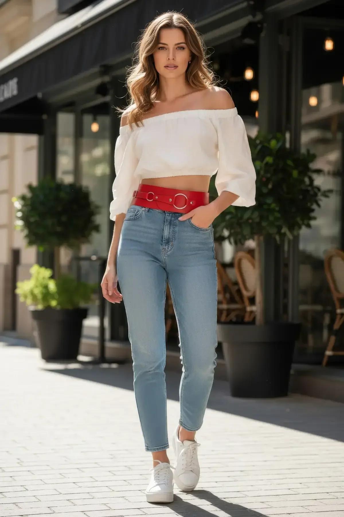 red faux leather waspie belt with triple silver O-rings worn at natural waist over white crop top and jeans