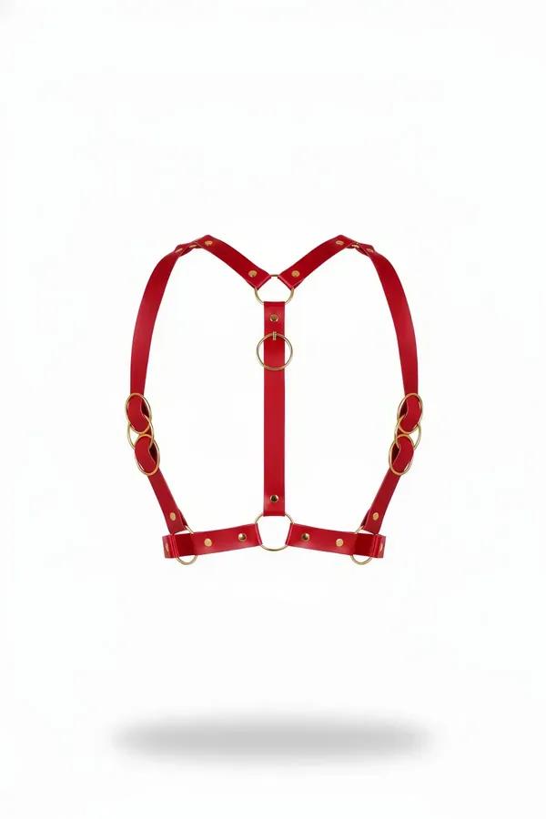 red faux leather chest harness with six gold-tone o-rings and Y-strap silhouette on white background