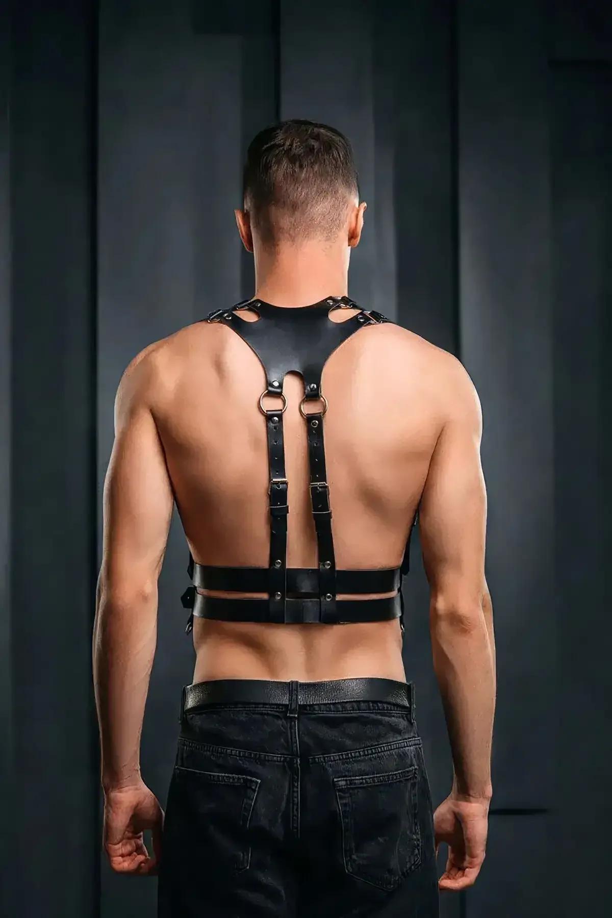 siyah vegan deri erkek body harness sırt görünümü, geniş omuz paneli ve D-halkalar, koyu metal toka detayı
