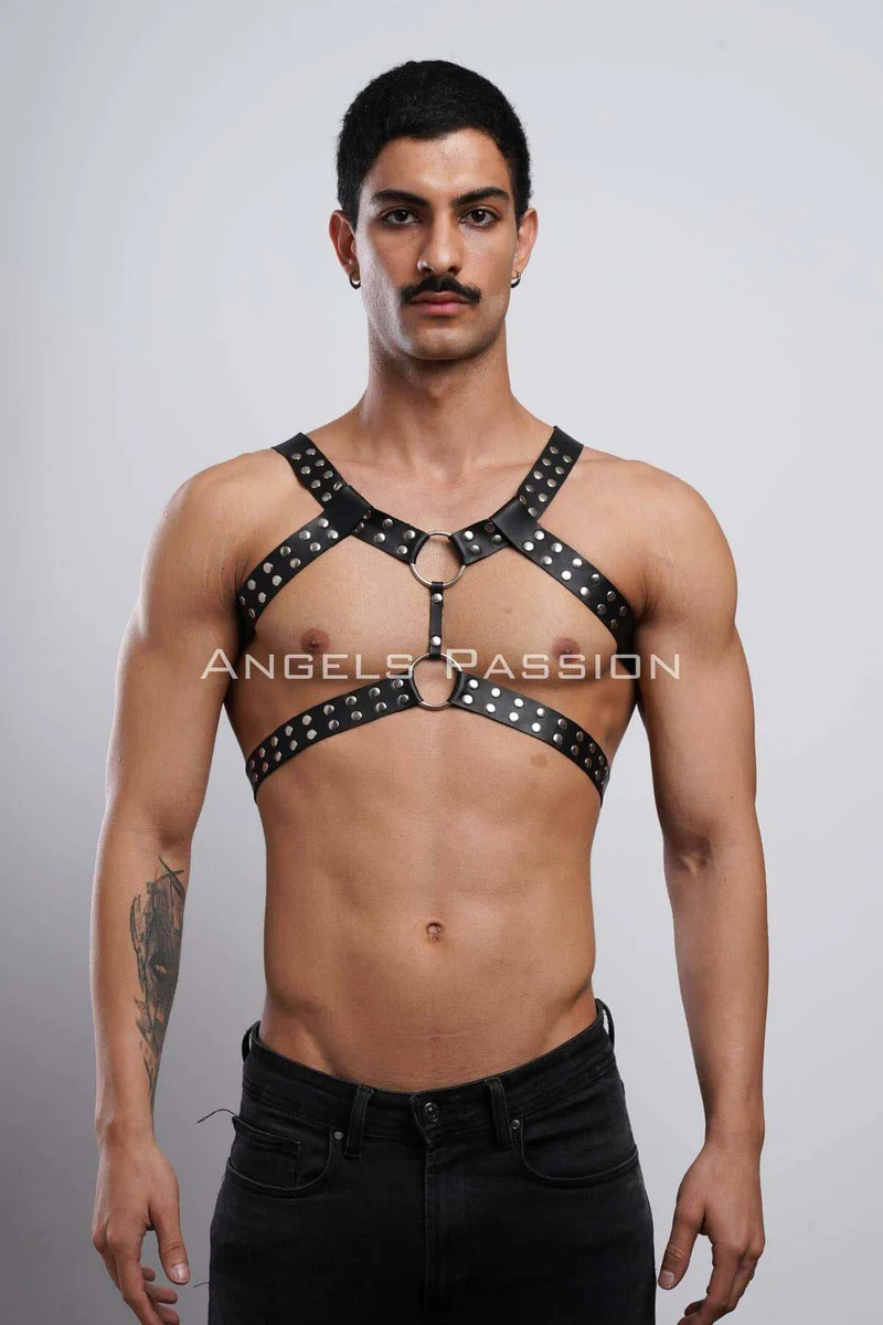 Close-up of black faux leather strap with silver stud detail on chest harness