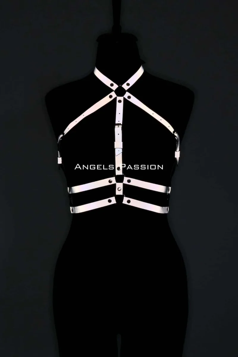 Model wearing the reflective chest harness over a black dress with silver hardware