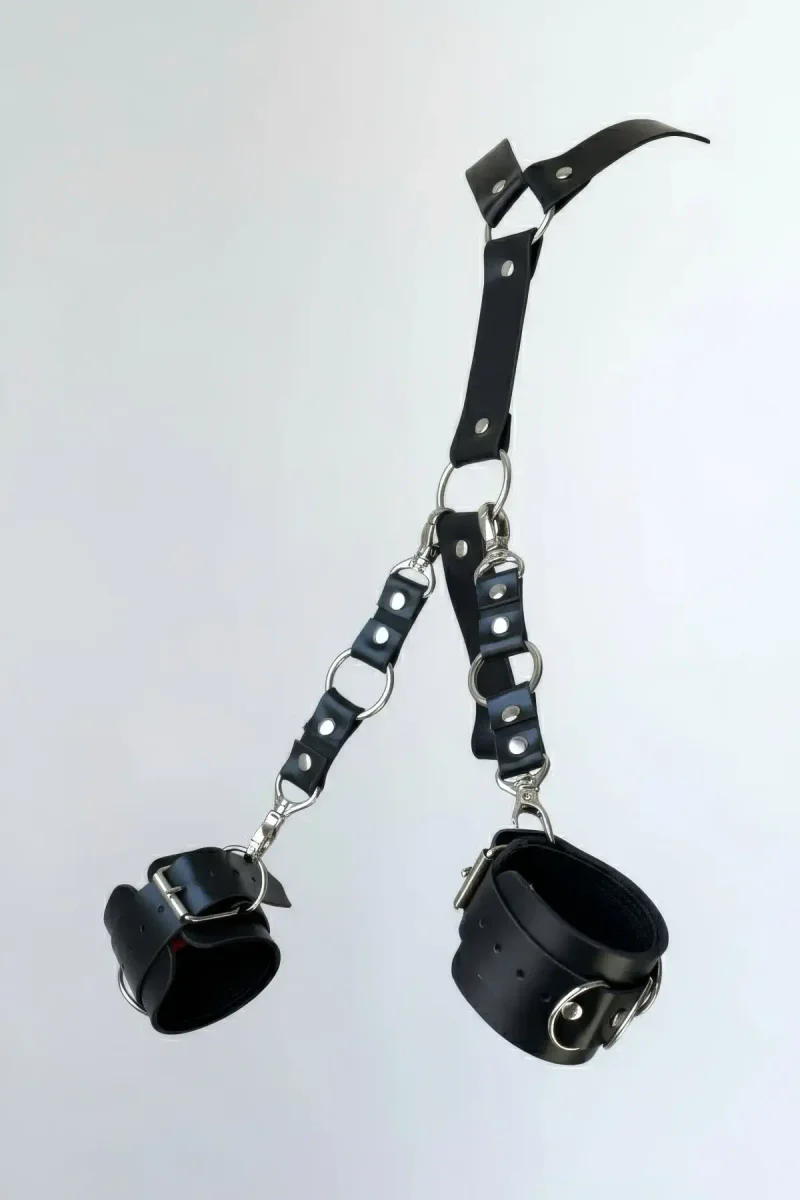 Black faux leather handcuff set with detachable O-ring chain and silver hardware