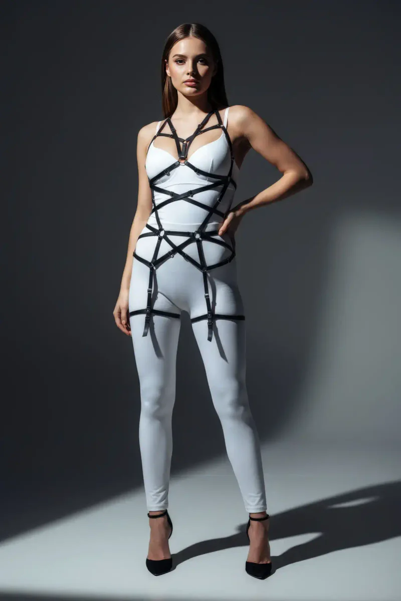 Black strappy body harness with O-ring detail worn with white leggings and black heels