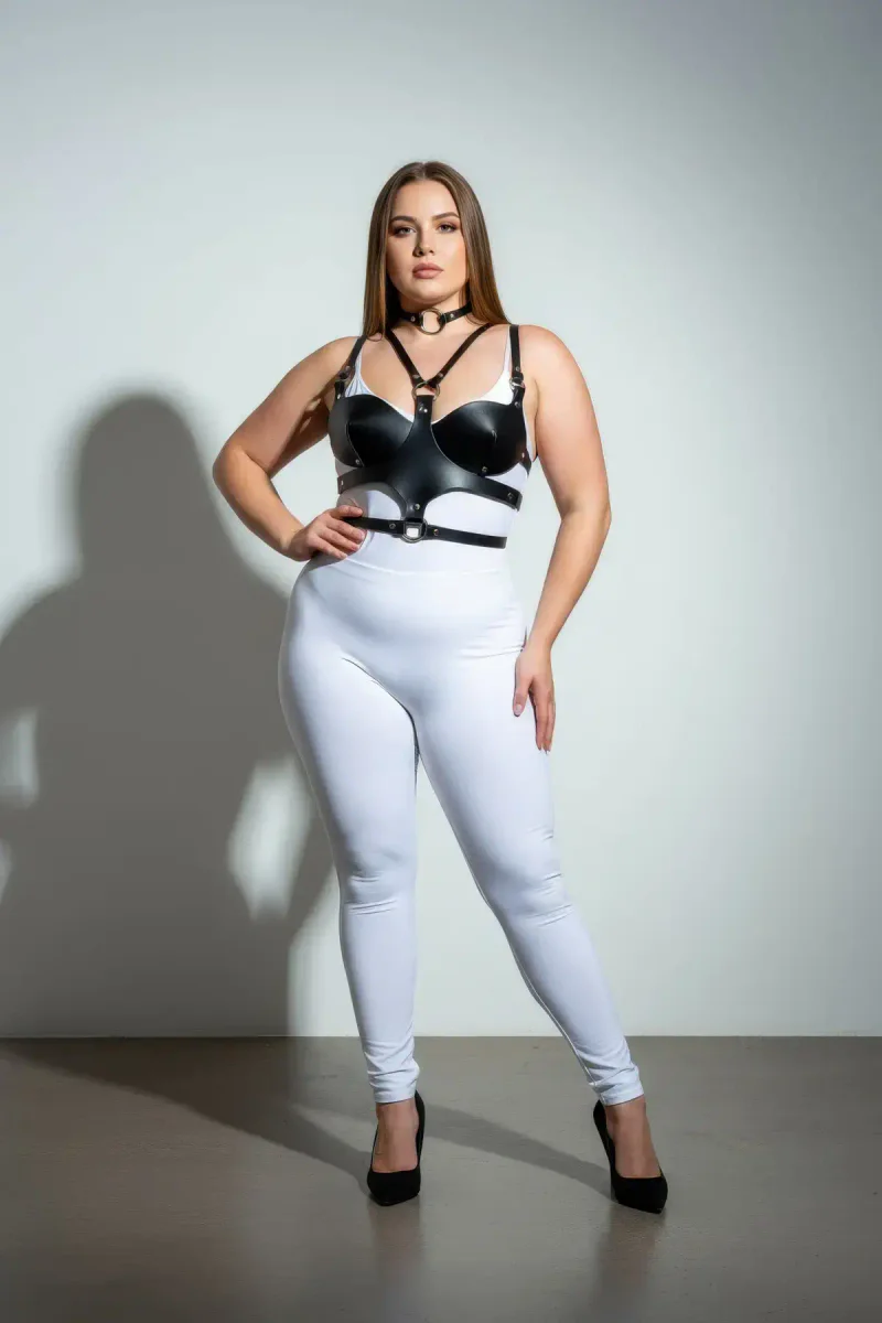 Black faux leather chest harness with choker set, model wearing white leggings and black heels
